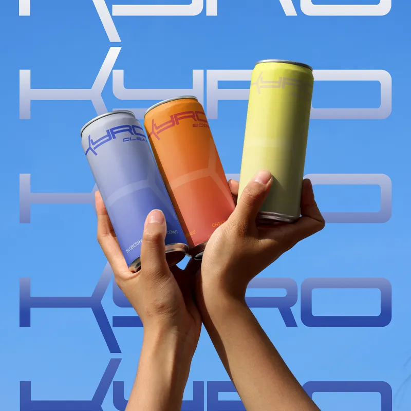 Hands holding three colourful KYRO drink cans against a bright blue background.
