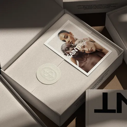Open beige gift box with a Saintpeau postcard and wax seal on tissue paper.