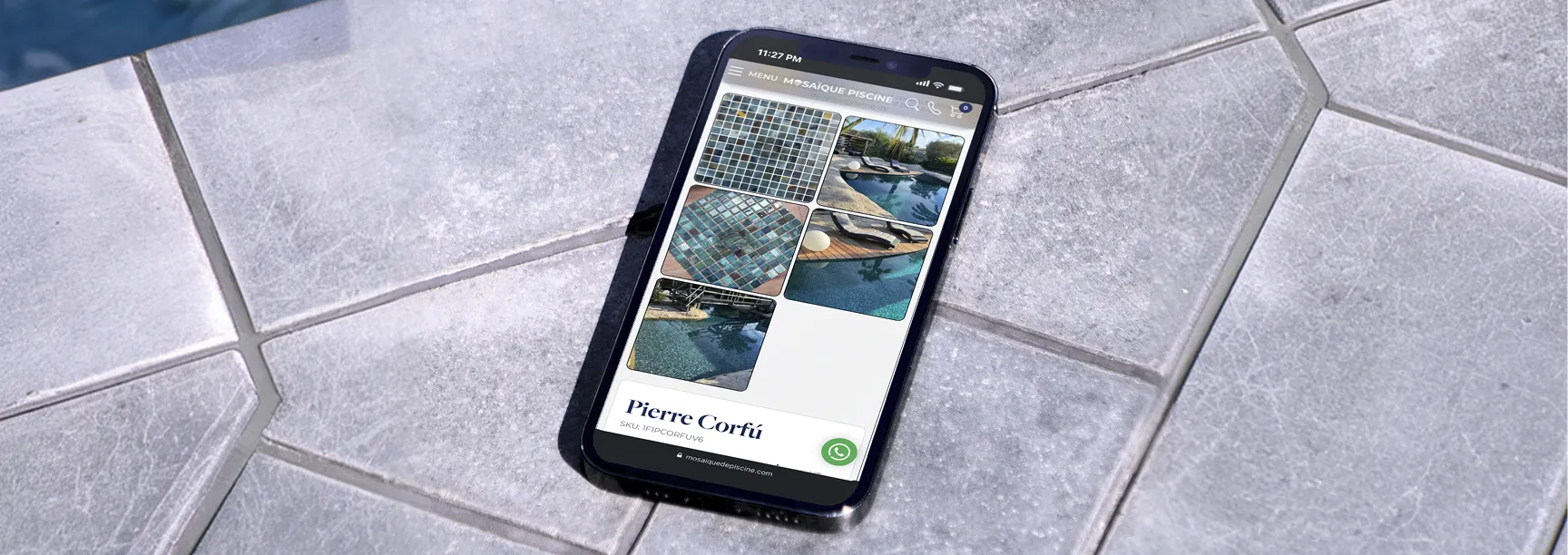 Smartphone on grey stone tiles showing the Mosaïque Piscine site and its mosaic pool tiles